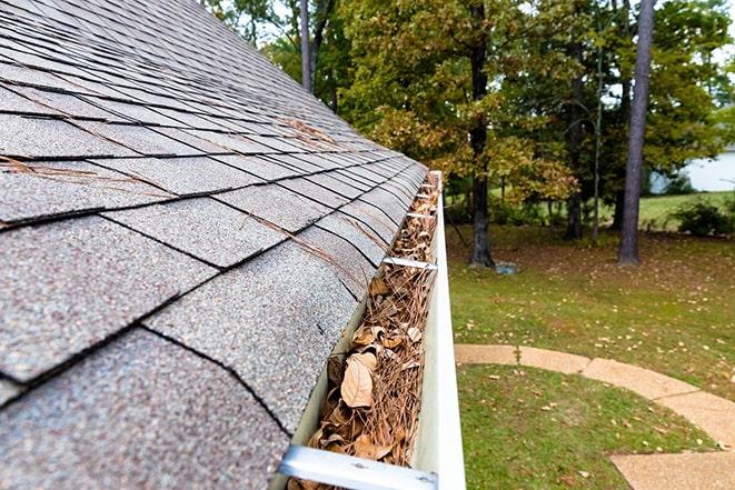 a professional cleaning a residential gutter